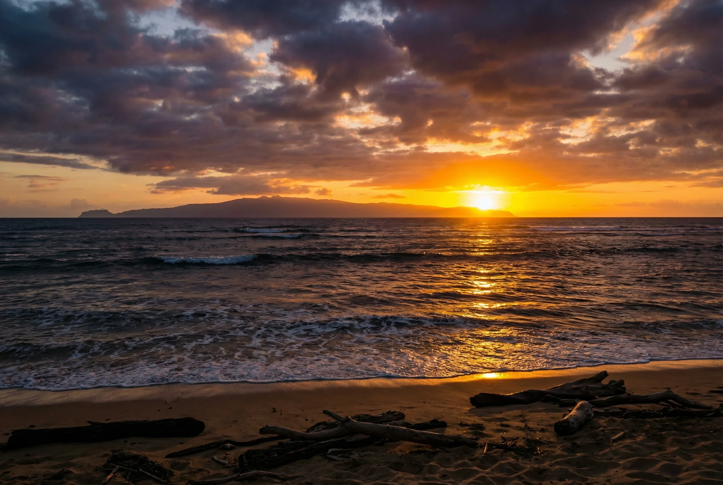 Breathtaking golden hour sunset at Kekaha Beach Park Kauai, with the silhouette of the Forbidden Isle of Niihau visible on the horizon.