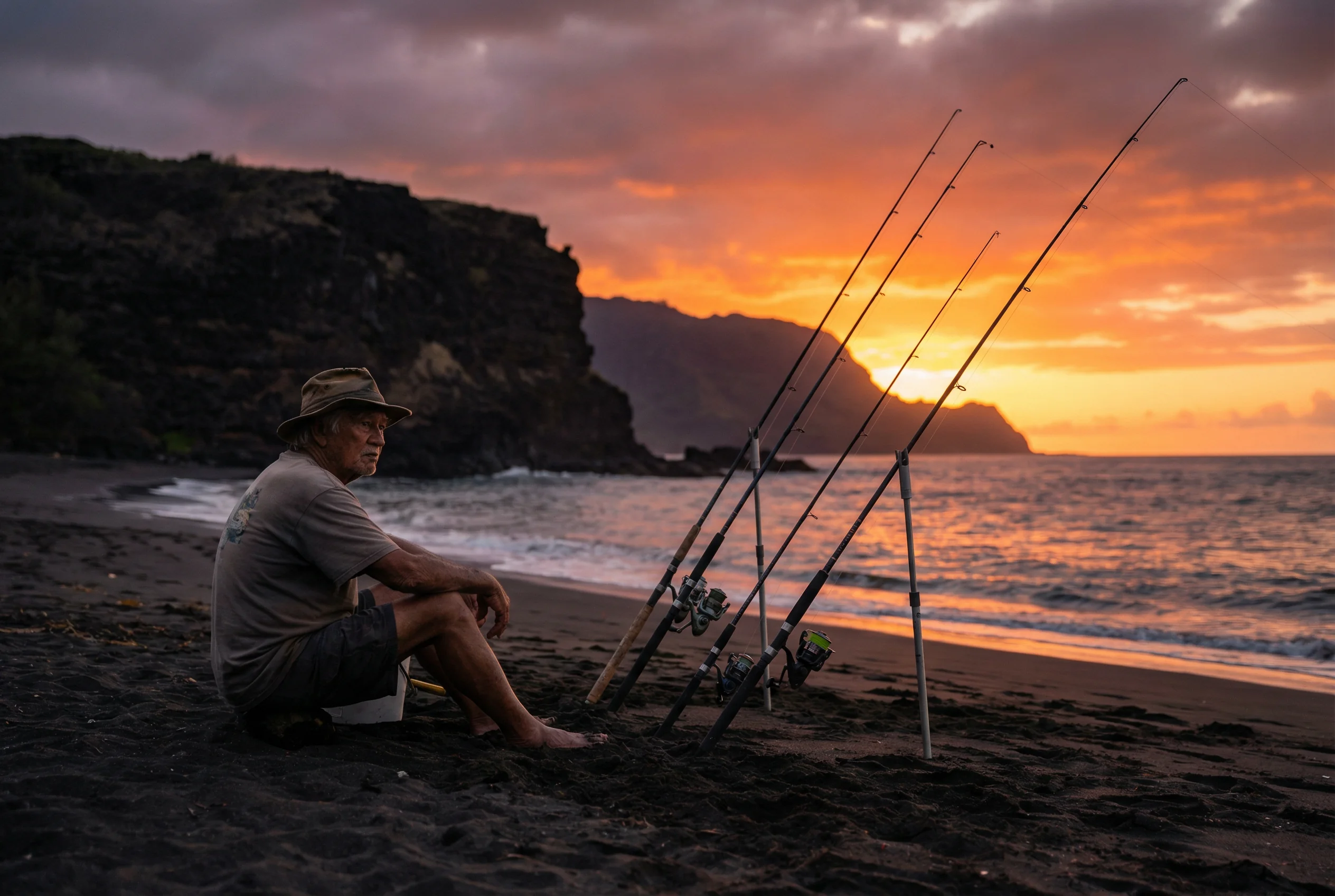 A local fisherman on the sandy shore of Kekaha Beach at sunset, following the traditional Kauai fishing culture for Ulua.